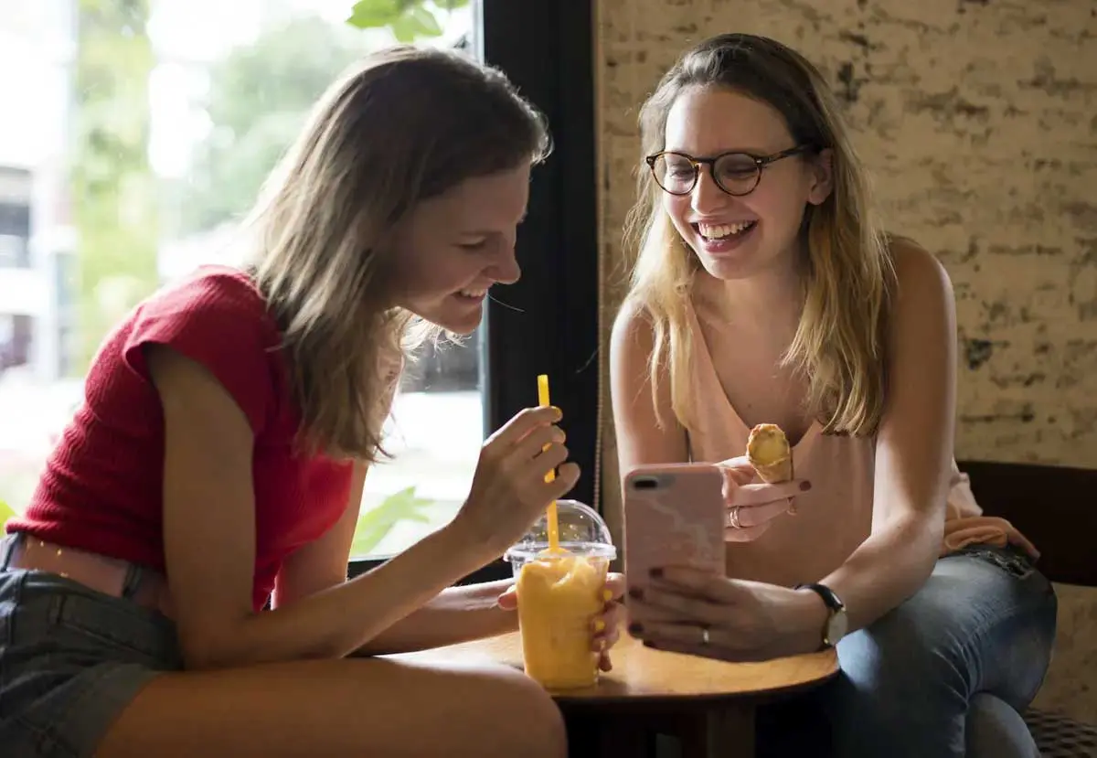 Students enjoying a snack while looking at phone